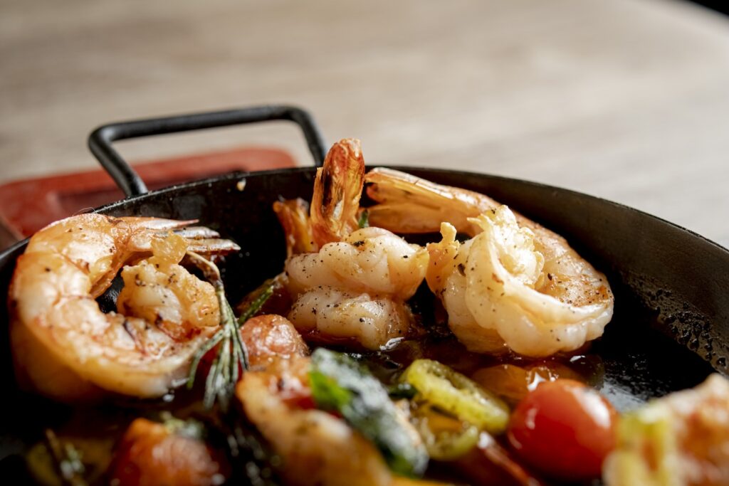 Cooked shrimp with tomatoes and herbs in a pan